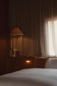 a bedroom with a bed and a lamp and a window at 蜜圡 Mitzdo in Tamano