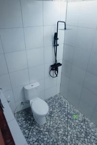 a bathroom with a toilet and a phone on the wall at El-Mindri Bungalow dan Resto in Gili Gede +39 photos
