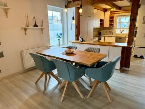 a kitchen with a wooden table and chairs at Ferienhaus Schlummerkoje in Friedrichskoog