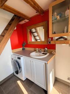 a bathroom with a sink and a washing machine at Maison dans le Beaujolais vert in Thizy-les-Bourgs