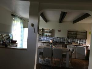a kitchen with a table and chairs and a kitchen with a window at Grande maison entre vert et bleu in Saint-Yrieix-la-Montagne +13 photos