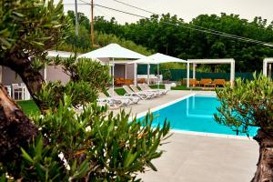 a pool with chairs and umbrellas in a yard at Mary Pool - Giada in San Vito Chietino