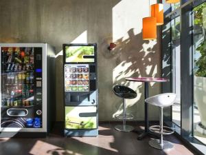 a drink vending machine next to a bar with a stool at Ibis Budget Lyon Centre - Gare Part Dieu in Lyon
