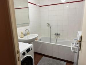 a bathroom with a sink and a tub and a washing machine at Bartholomé LE MAGNIFIQUE in Drancy