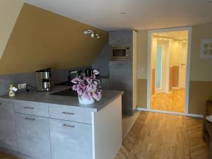 a kitchen with a counter with flowers on it at Heinrich Heine in Tangermünde +4 photos