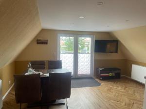 a living room with a table and chairs and a sliding glass door at Heinrich Heine in Tangermünde