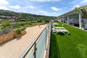 a balcony with green grass and white chairs at Mary Pool - Giada in San Vito Chietino