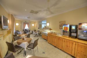 a living room with tables and chairs and a television at Allegro Hotel in St Julian's