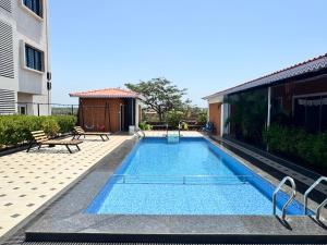 a swimming pool in the backyard of a building at Hotel Ashoka Kokan Ganpatipule in Ganpatipule