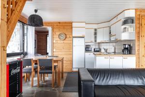 a kitchen and dining room with a table and chairs at Himos Mökki in Jämsä