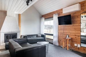 a living room with a couch and a fireplace at Himos Mökki in Jämsä