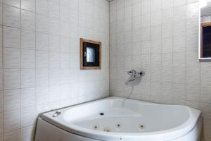 a white bath tub in a white tiled bathroom at Himos Mökki in Jämsä +41 photos