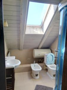 a bathroom with a toilet and a sink and a skylight at Guest House on Lesnaya in Leski +88 photos
