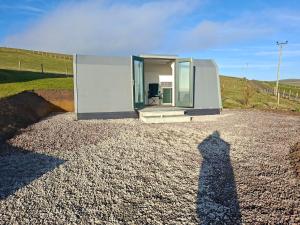 a person standing in front of a tiny house at The Orkney Pod in Stromness +11 photos