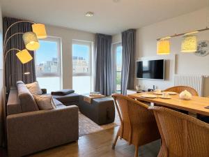 a living room with a couch and a dining table at Ostseeblick-Bollwark Whg 9 in Olpenitz