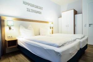 a large white bed in a hotel room at Ostseeblick-Bollwark Whg 9 in Olpenitz +21 photos