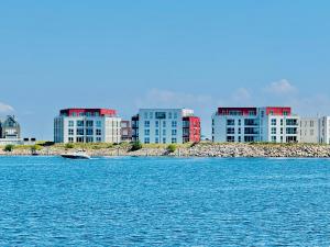 a boat in the water in front of buildings at Ostseeblick-Bollwark Whg 9 in Olpenitz