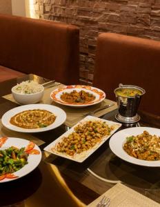 a table with many plates of food on it at Clarks Inn Suites Dhanbad in Dhanbād