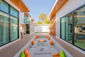 an outdoor patio with a couch and a table at Silver Hill Pool Villa Pattaya in Na Jomtien