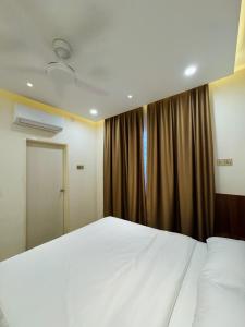 a bedroom with a large white bed and a window at Bayu Senja in Lahad Datu