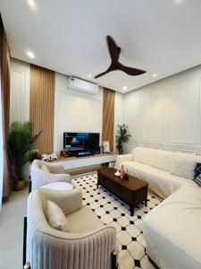 a living room with two couches and a ceiling fan at Bayu Senja in Lahad Datu