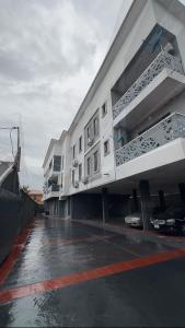 a large white building with a car parked in a parking lot at Luxury Homes in Lagos