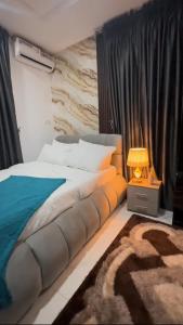 a bedroom with a bed and a lamp on a table at Luxury Homes in Lagos
