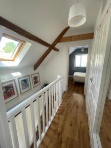 a room with a white staircase with a window at Copswood Cottage in Stroud
