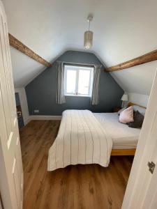 a bedroom with a bed and a window at Copswood Cottage in Stroud