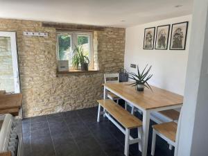 a dining room with a wooden table and chairs at Copswood Cottage in Stroud