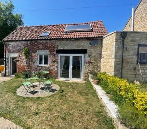 a small stone house with a solar roof at Copswood Cottage in Stroud