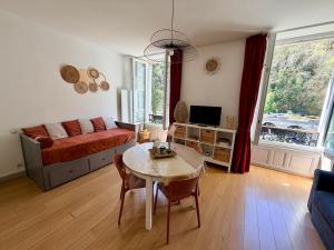 a living room with a table and a couch at Le Nid Ossalois in Eaux-Bonnes