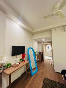 a living room with a table and a blue chair at Kervan stays in Greater Noida +11 photos