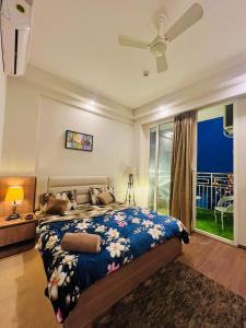 a bedroom with a bed and a large window at Kervan stays in Greater Noida