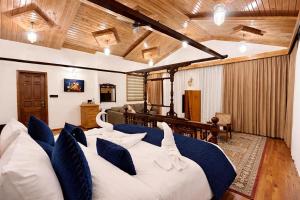 a bedroom with a large bed with blue and white pillows at Chillaru Spa & Resort in Kasauli