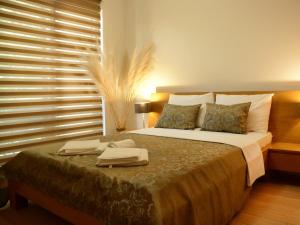 a bedroom with a bed with two towels on it at Apartments Villa Splendor in Vrnjačka Banja