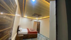 a small room with a bed and a ceiling at Nishad Raj bhawan in Vrindāvan