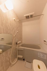 a bathroom with a bath tub and a toilet at HARUSAKU Omachi in Asahikawa +35 photos