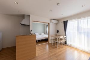 a room with a bed and a table and a bedroom at HARUSAKU Omachi in Asahikawa