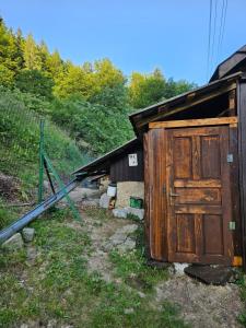 ein altes Gebäude mit einer Holztür neben einem Zaun in der Unterkunft Only Meadow in Kolárovice + 6 Fotos
