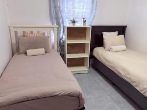 a bedroom with two beds and a book shelf at 38 stay in eMalahleni +4 photos