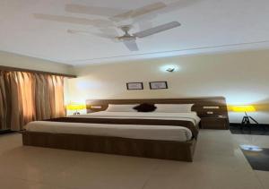 a bedroom with a large bed with a ceiling fan at SHR Resort in Rudraprayāg +6 photos
