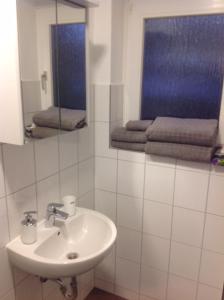 a white bathroom with a sink and a mirror at Apartment Kleine Kremper in Glückstadt