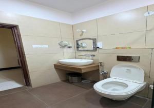 a bathroom with a toilet and a sink at SHR Resort in Rudraprayāg