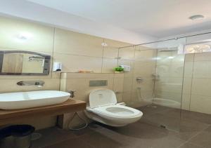 a bathroom with a toilet and a sink and a shower at SHR Resort in Rudraprayāg