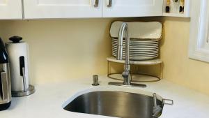 a sink in a kitchen with a stack of plates at Casseus J Legacy in Rosedale +118 photos