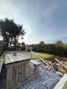 a wooden picnic table sitting in the middle of a yard at Sandytoes Cottage in Pentraeth