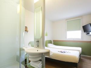 a bathroom with a sink and two beds at ibis budget Romorantin in Romorantin +39 photos