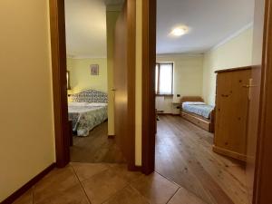 a room with two beds and a door to a bedroom at Trilocale Carisolo 014 in Carisolo