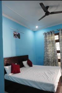 a bed in a blue room with a ceiling fan at Ds Royal Inn in Malhour